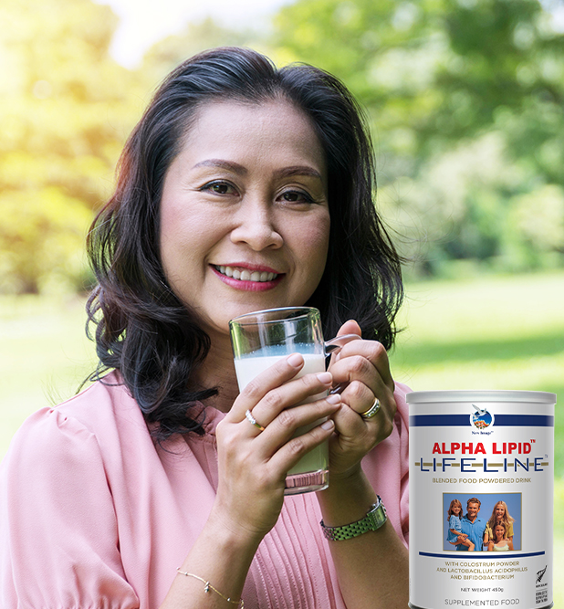 Healthy drink lifestyle concept. Senior woman 50 s hands holding a glass of fresh milk in the park.